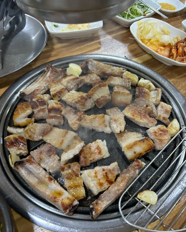 마장동숯불구이 돼지 생갈비 — 신선한 갈빗살이 숯불 위에서 노릇하게 구워지는 모습