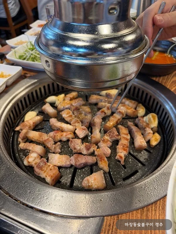 참숯 불판 위 돼지 오겹살이 구워지는 매장 식사 장면 — 노릇하게 익어가는 두꺼운 오겹살