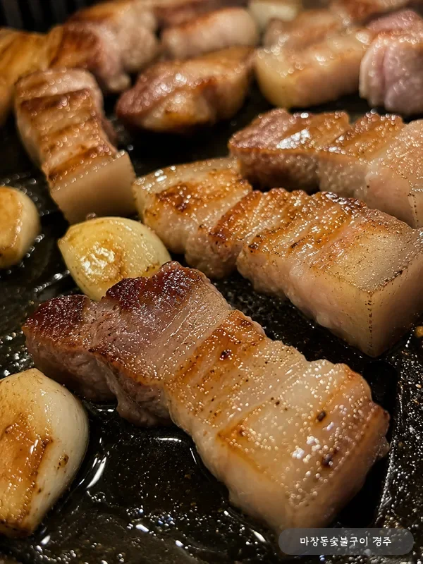 노릇하게 구워진 돼지 오겹살 클로즈업 — 두꺼운 비계와 살코기 단면이 캐러멜라이즈된 표면 매크로 컷